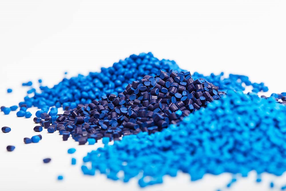 Different shades of blue polymer beads that will be melted for plastic injection molding