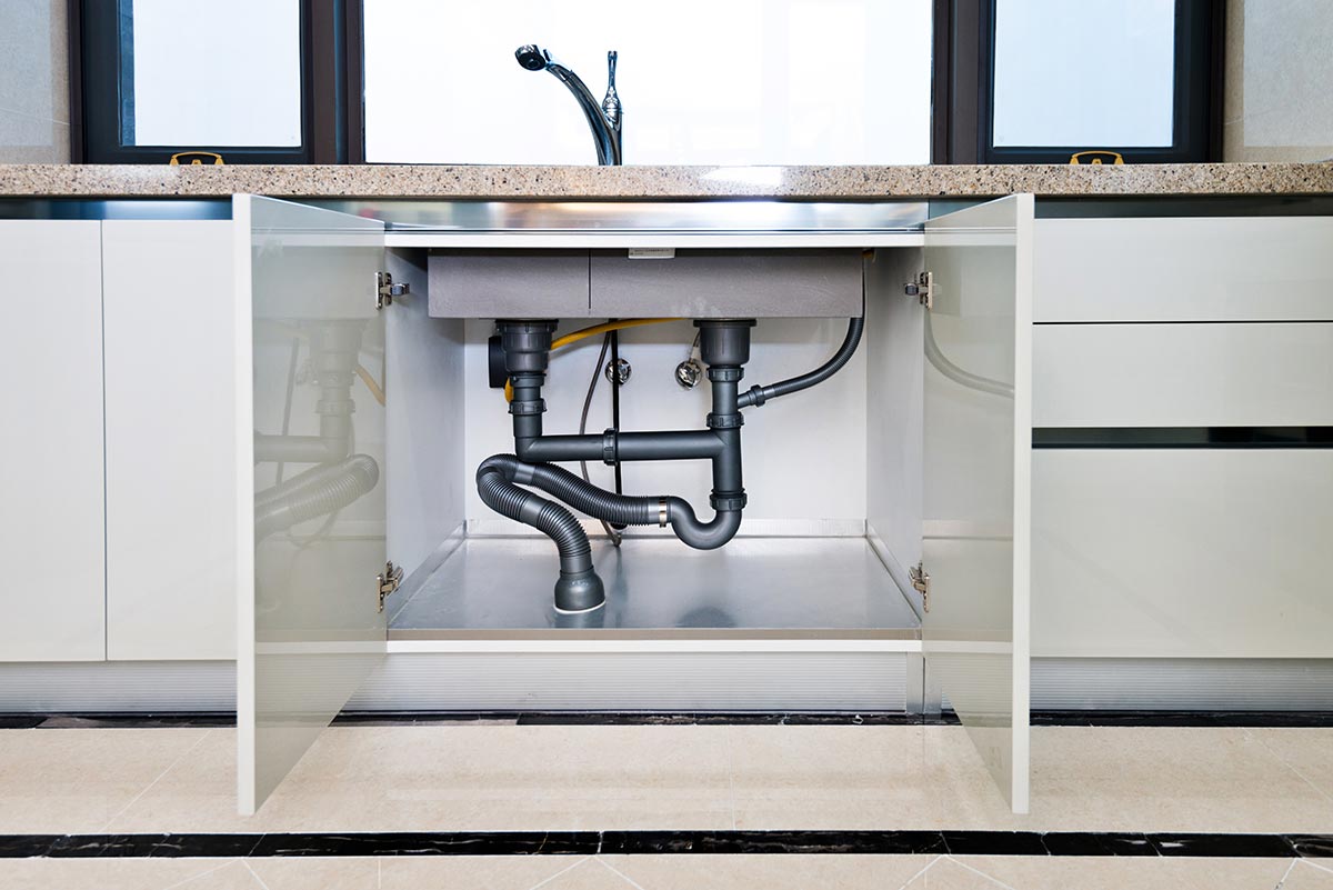 Water pipe and plumbing under a modern kitchen sink Plastic Plumbing
